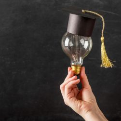 person-holding-light-bulb-with-graduation-cap-e1698743004419